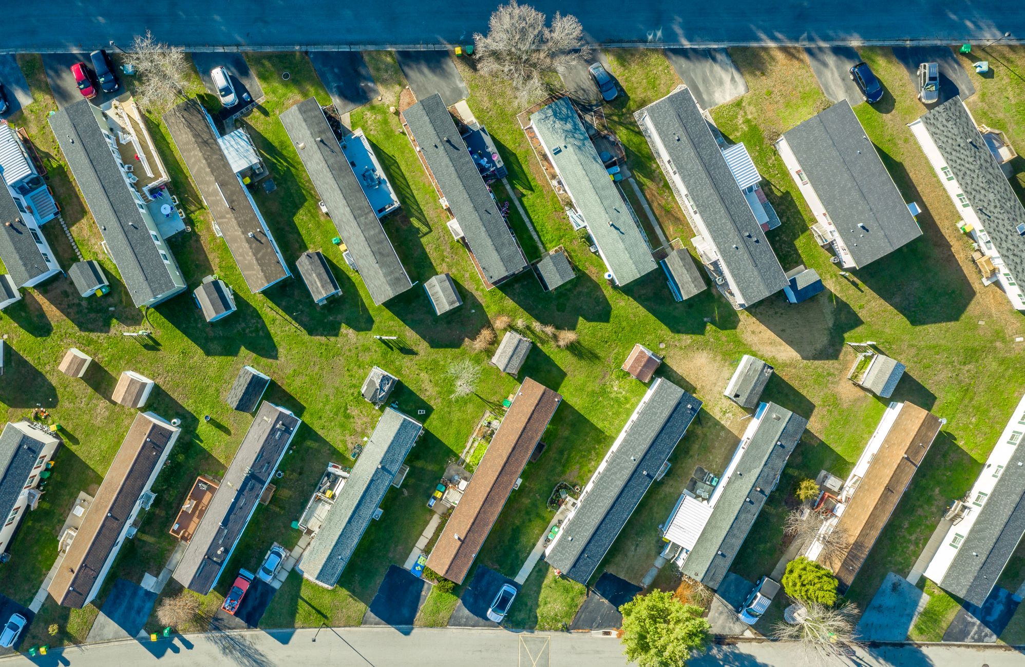 An aerial view of a manufactured home community, where multiple homes are lined up in rows.