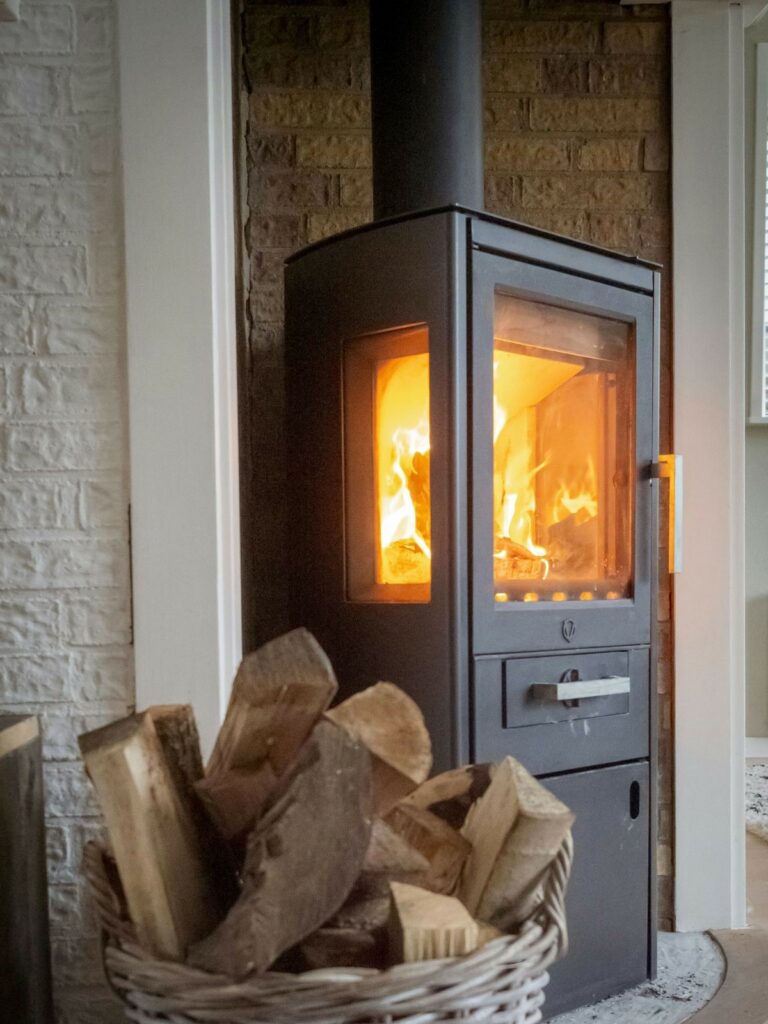 Wood burning stove with a basket of wood nearby