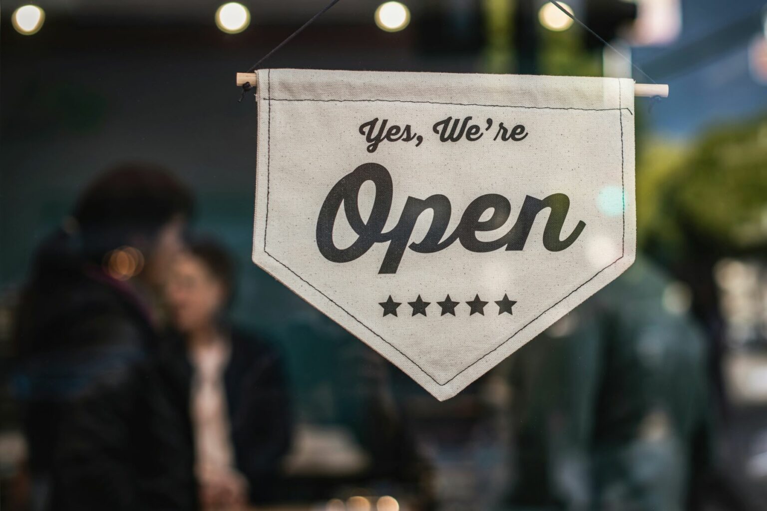 Canvas sign hanging on a business window that reads “Yes, we’re open.” Implies someone is looking for home inspection leads and curious how to get work as a home inspector.