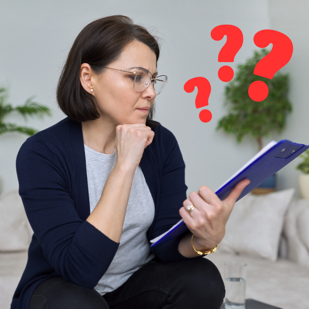 Woman with short hair and glasses stares at a clipboard with question marks floating next to her face. Implies confusion about a home inspection bad sewer line after a client's inspector forgot her sewer scope service.