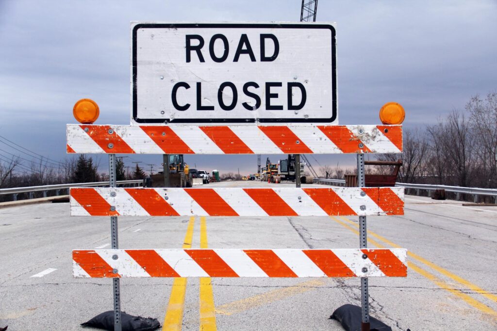 A freeway caution sign that says "Road Closed," illustrating how inspectors should defer home inspection repairs to specialists.