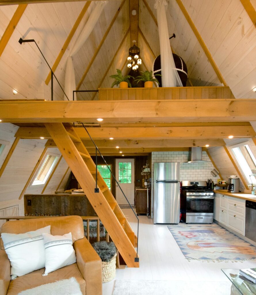 A tiny home with a loft on top and a kitchen below.